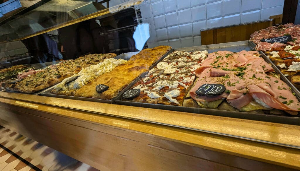 Many outlandish and colorful pizza creations using out-of-the-box ingredients are displayed deli style at Bonci Pizzarium