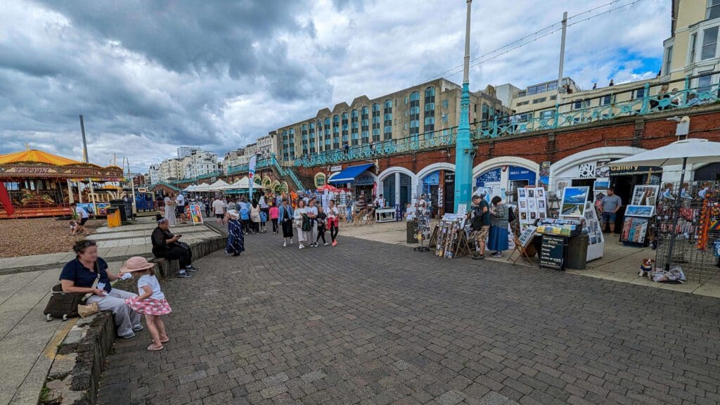 Along the beach the Brighton Boardwalk filled with rides, people, and shops selling handmade artwork