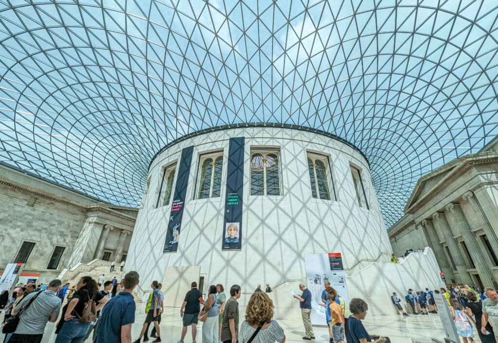 Gorgeous triangle designed windows overtop white circular walls and stone entrances housing exhibits at the British Museum