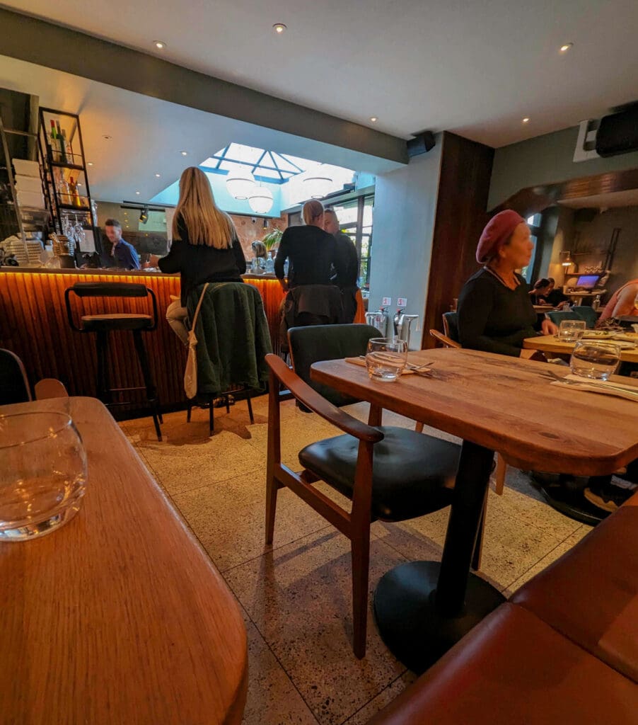 People sit at the bar and at tables inside the inviting Burnt Orange restaurant