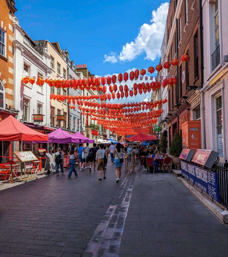 Shops and restaurants line the street underneath the many traditional Chinese lanterns strewn back and forth 