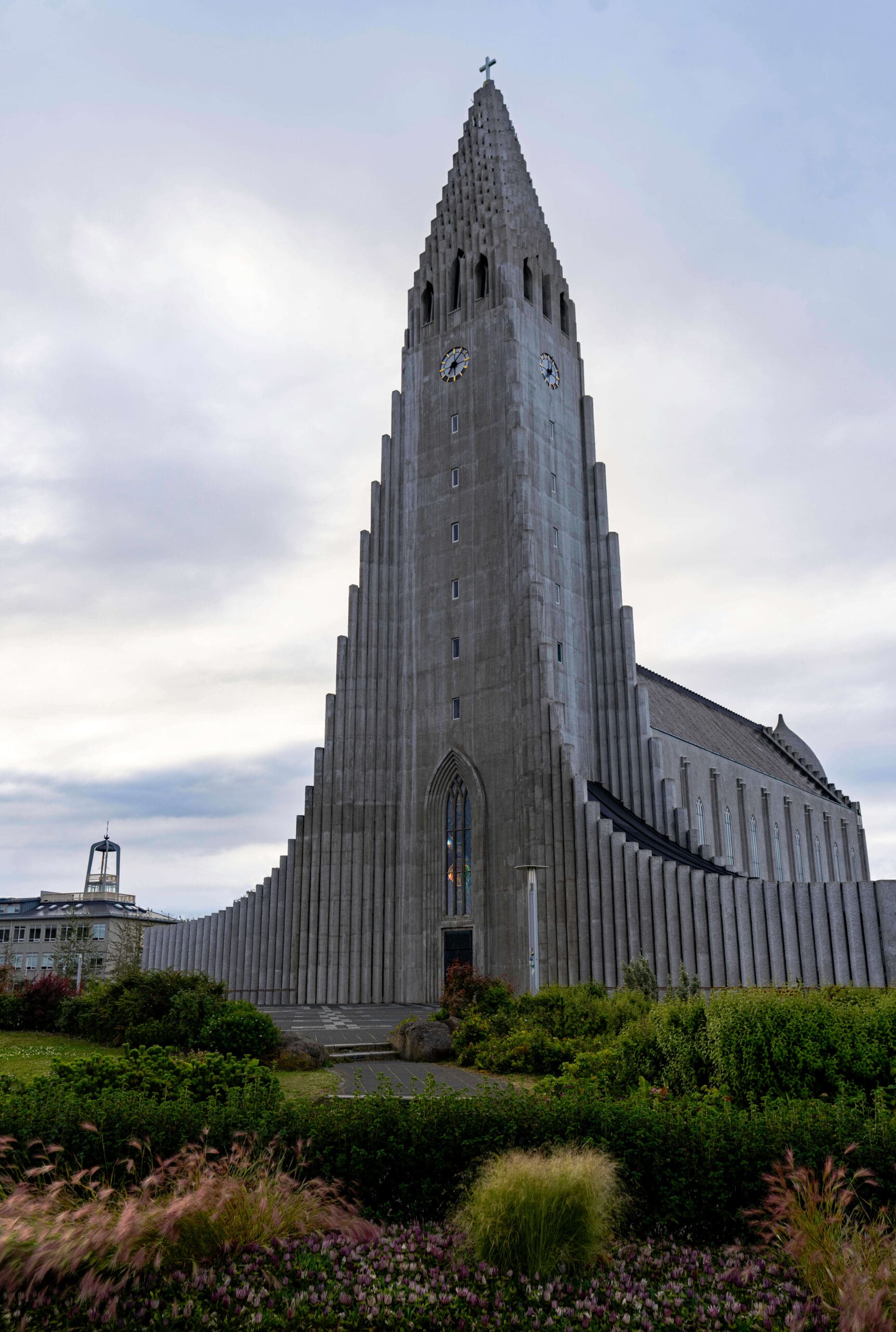 The gray pillard Hallgrimskirkja Church towering above the garden