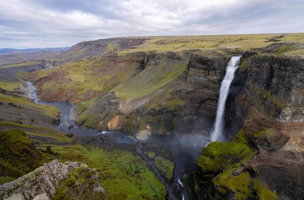 A vast and deep canyon expanding into the distance featuring one of the large Haifoss waterfalls