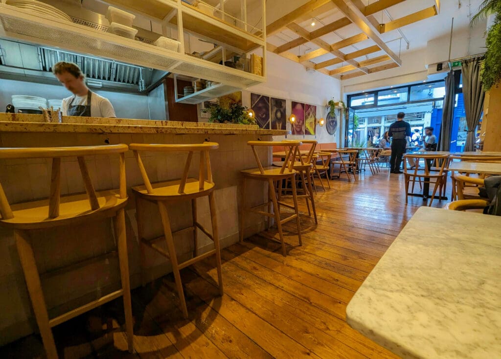 The tables and open kitchen bar area create a chic homely atmosphere at "Kindling" the best restaurant in Brighton