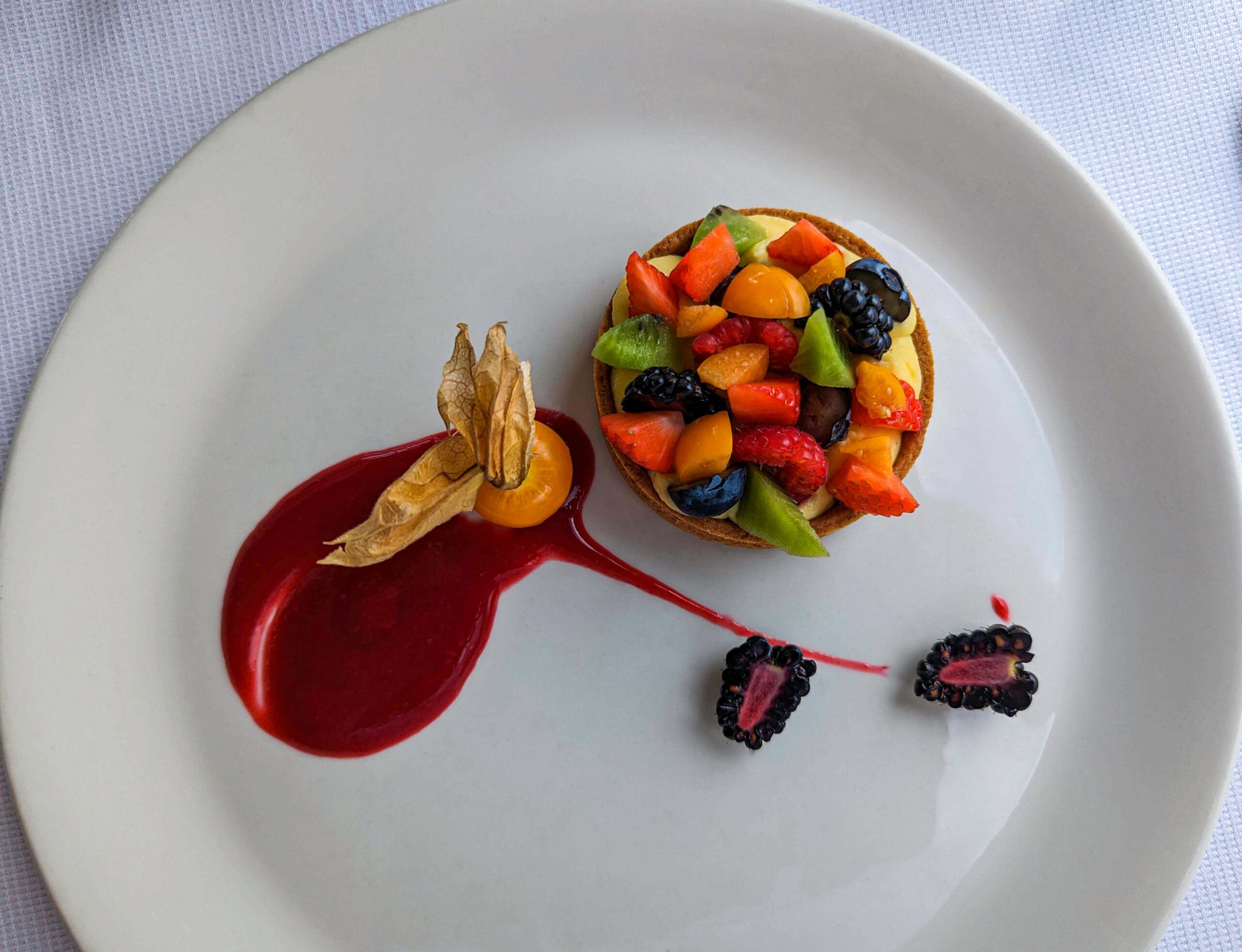 Finley prepared fruity desert tart with many colors and a red fruit sauce at La Loggia del Piazzale Michelangelo in Florence