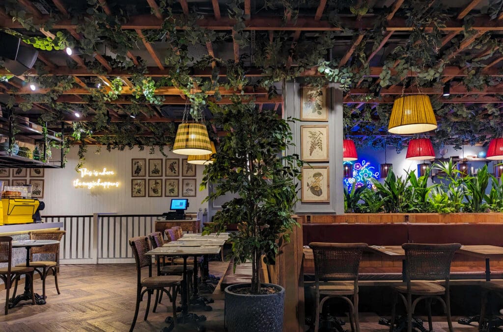 Latticed vines drape the ceiling accompanied with other plant life that makes up the interior of Leto