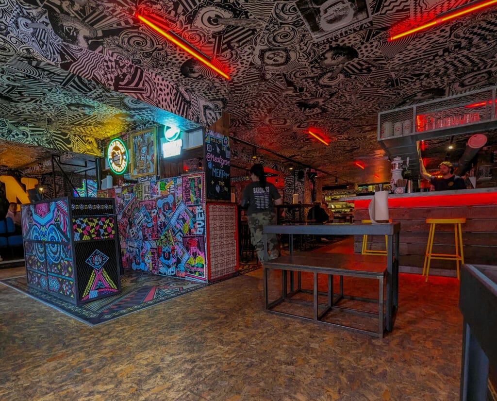 Crazy graffiti like patterns bathed in red neon lights cover the walls and ceiling of Meat Liquor in Brighton England