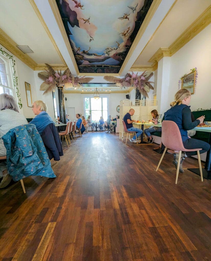 A stunning mural painted on the ceiling decorates the top of the elongated Oeuf - Cafe in Hove restaurant