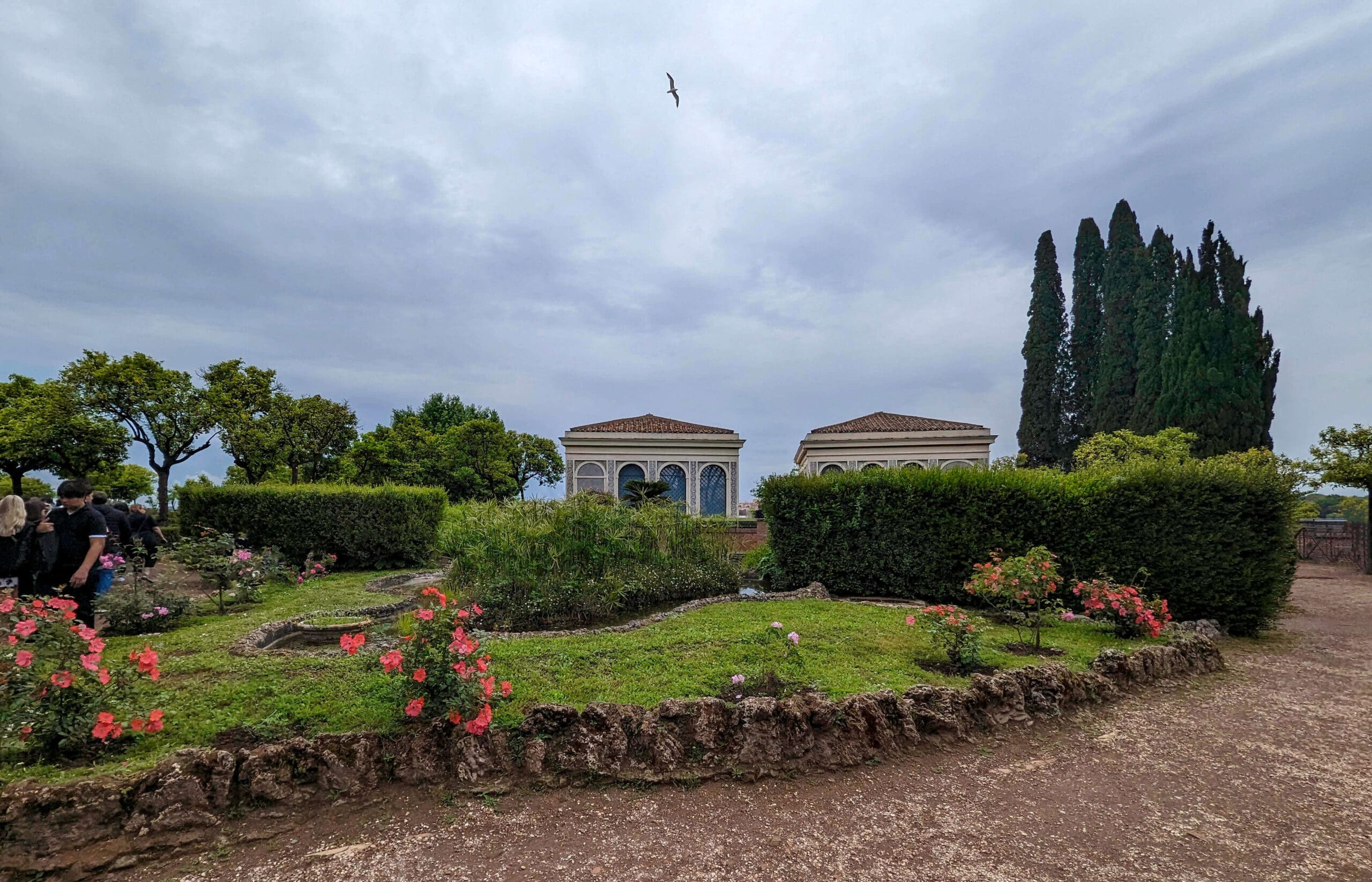 Beautiful trees, bushes, and pink flowers make up the top of the Roman Forum at Palatine Hill