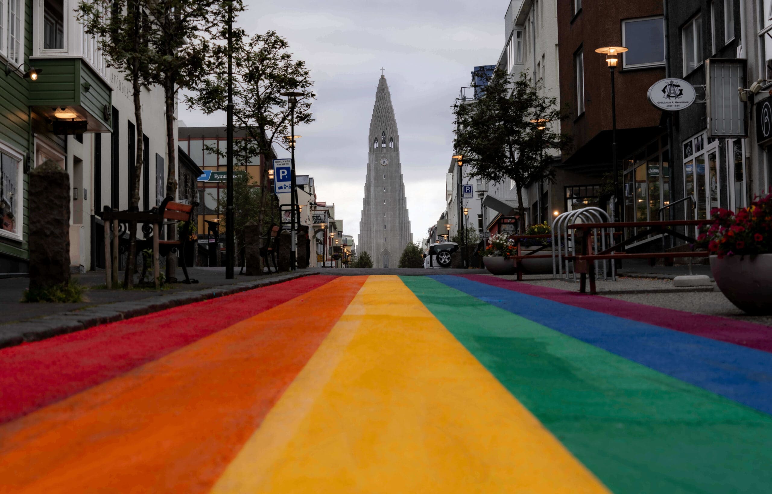 Bright colored Iceland Rainbow Street lined with shops leading to the Hallgrimskirkja Church