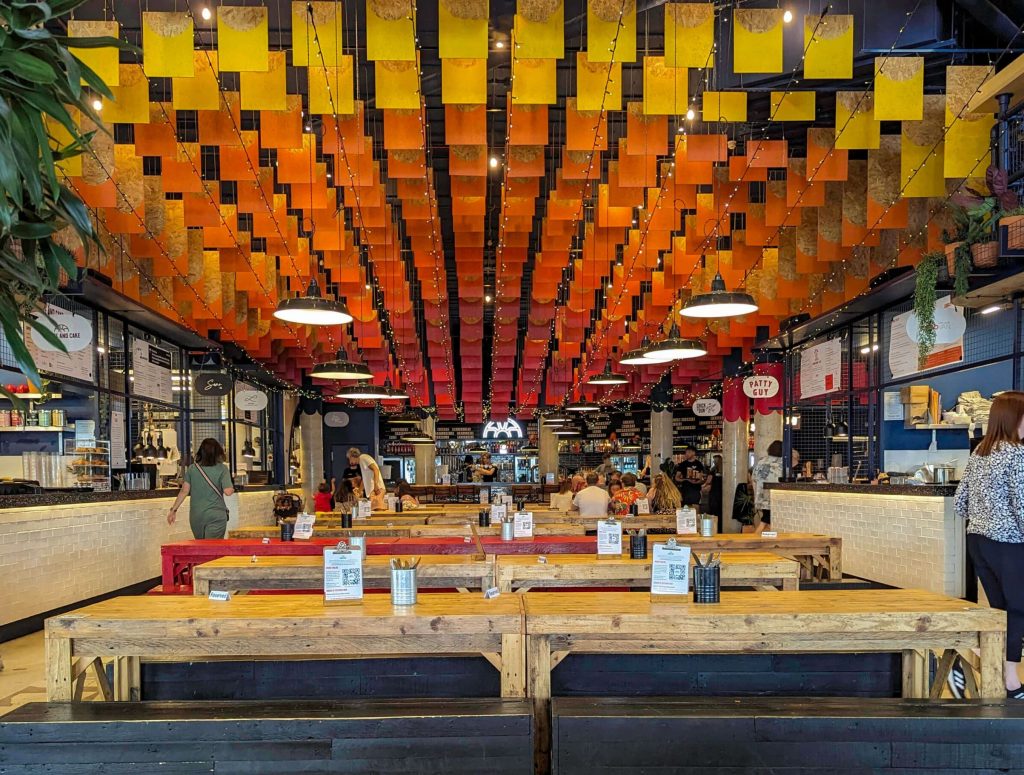 Yellow, orange, and red colors cover the ceiling inside Shelter Hall, one of Brighton's most popular restaurants