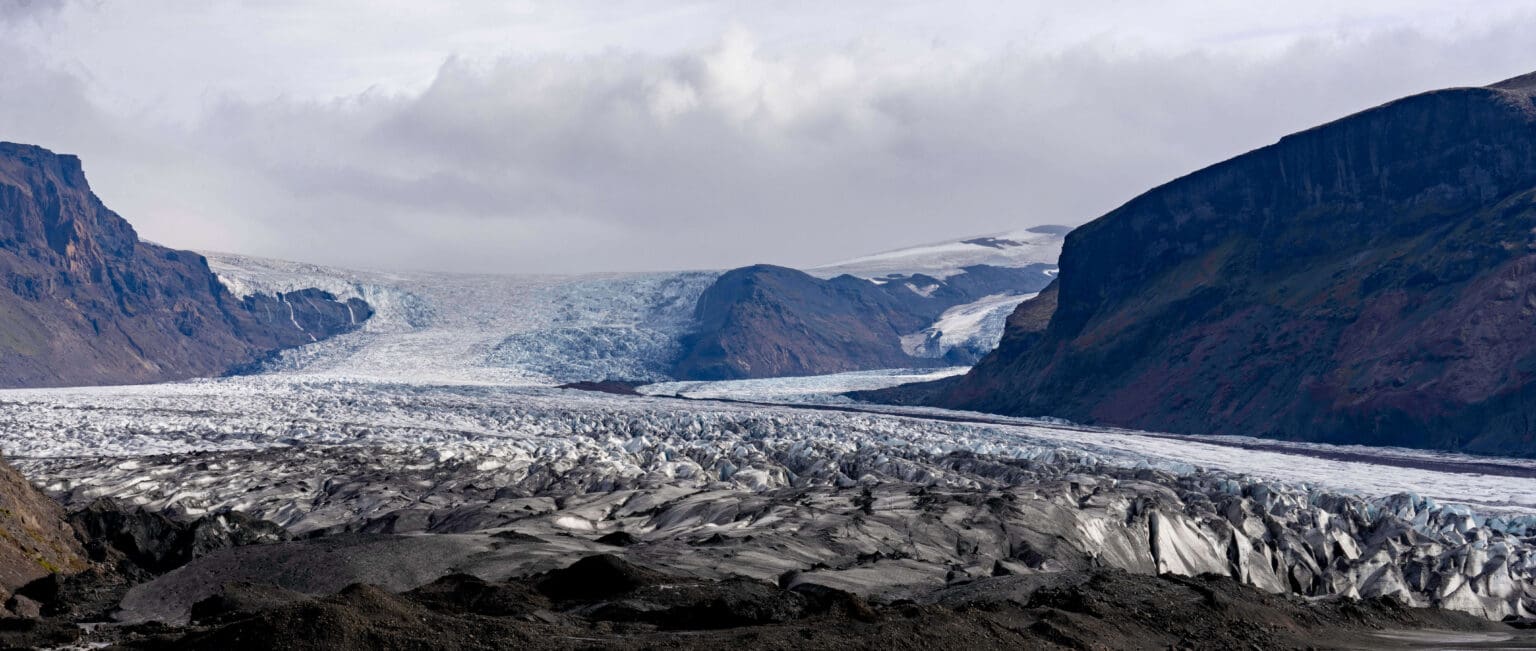 The immense ice of the Skaftafell Glacier covering the mountains and valley below