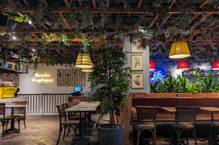 Latticed vines drape the ceiling accompanied with other plant life that makes up the interior of Leto