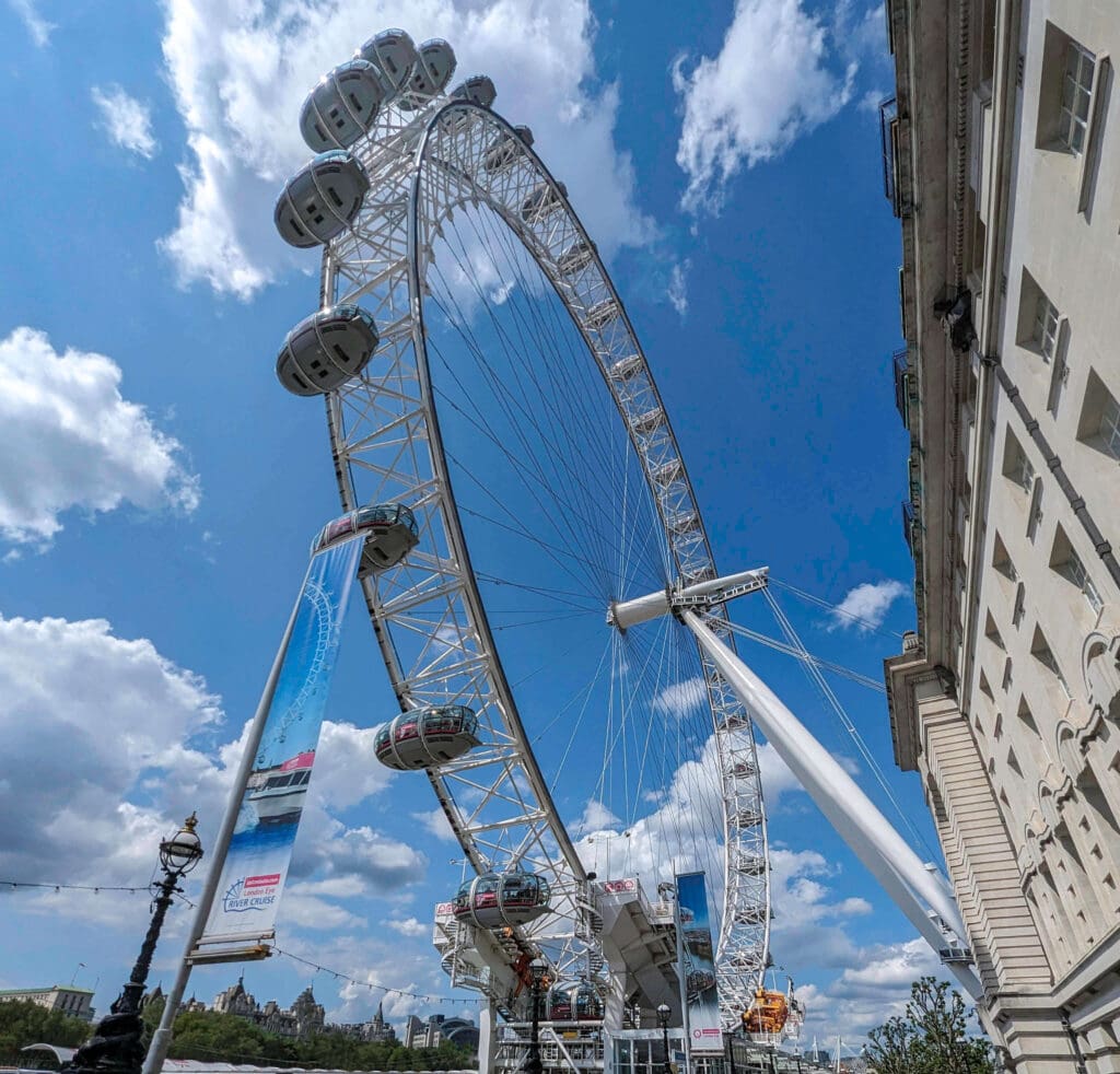 Looking up at the dozens of pods of the London Eye as it spins around overlooking the Thames river