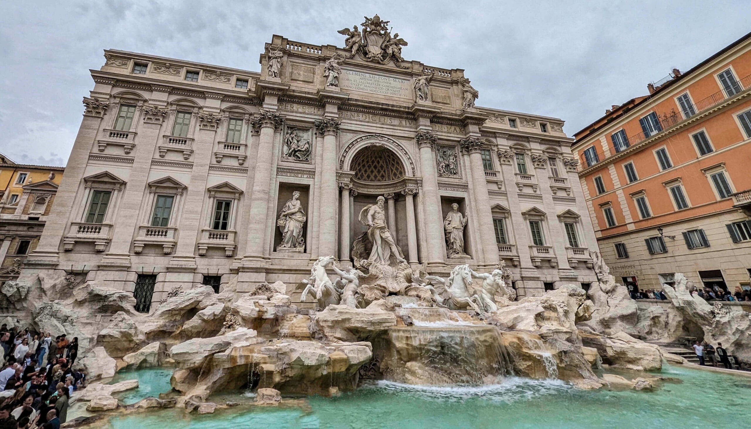 Incredible stone fountain with carved statues top a large fountain with flowing water found in the center of Rome