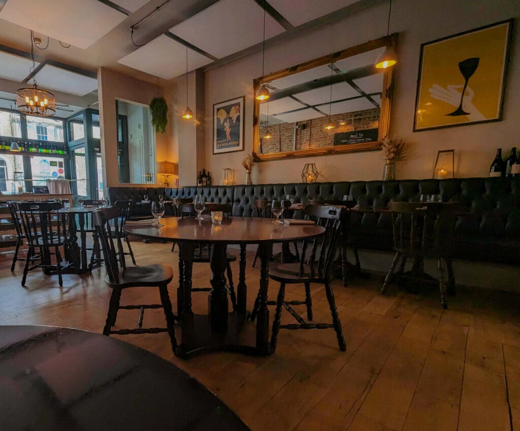 Open wooden tables and chairs under soft lighting make up elegantly rustic interior of Wild Flor