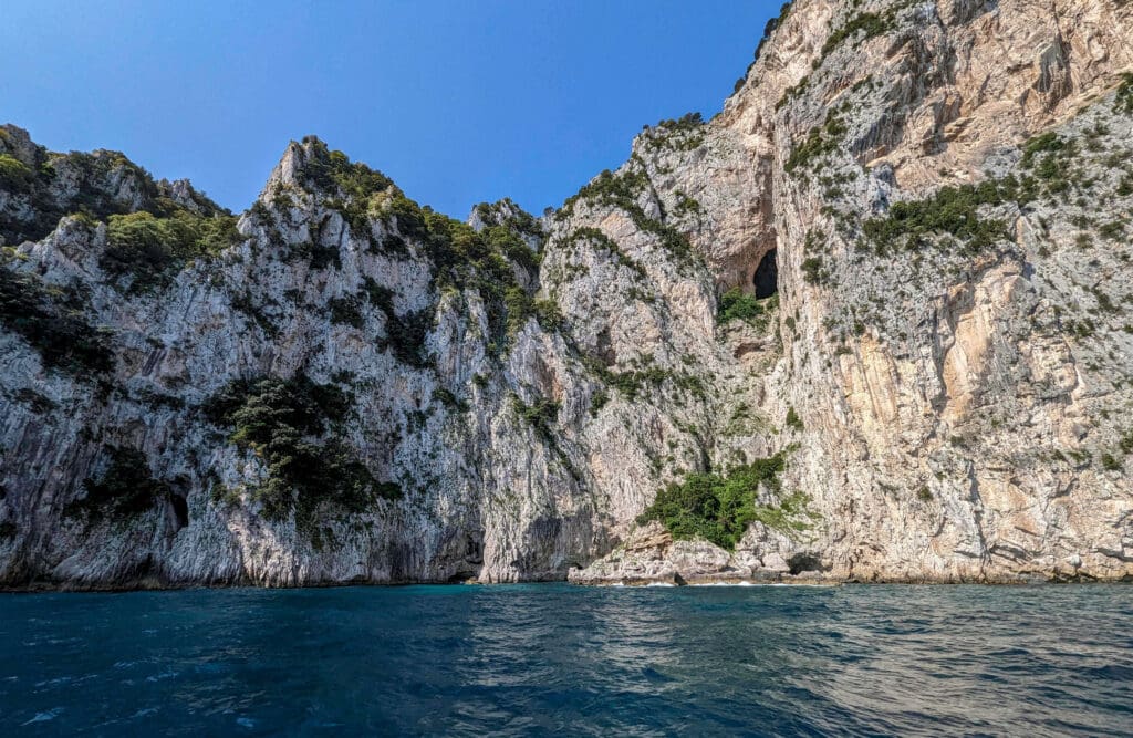 Boating next to the white rocky cliffs shooting straight up from the dark blue waters around Capri