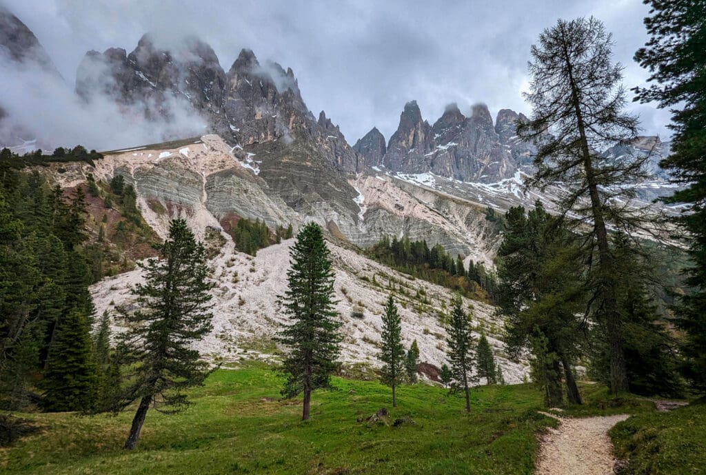 The Adolf Munkel Trail on the edge of the woods at the base of the towering Dolomite mountains