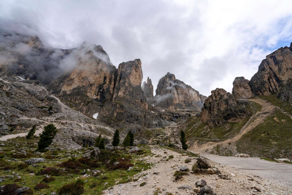 A gravel trail leads up into the skyscraping mountains of the Vajolet Towers