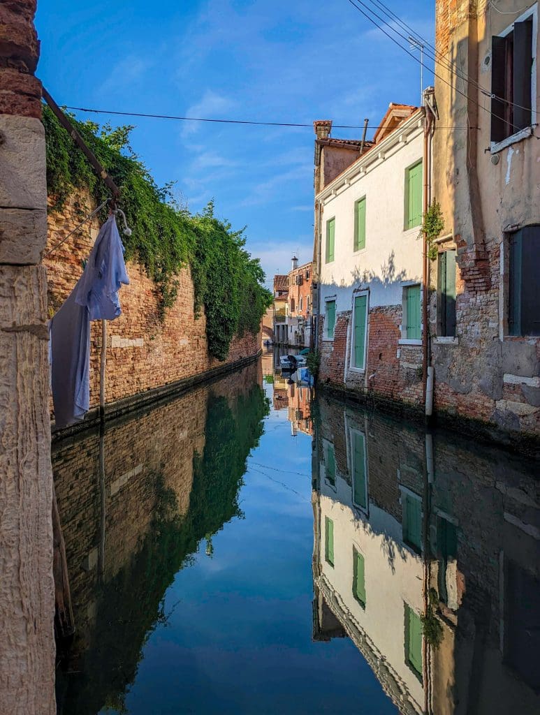 The still waters of a peaceful residential canal in the eastern half of Venice is one of the best things to do in Italy