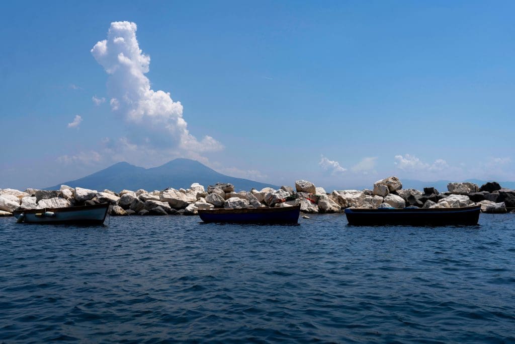 A string of rowboats in the calm bay of Naples Italy