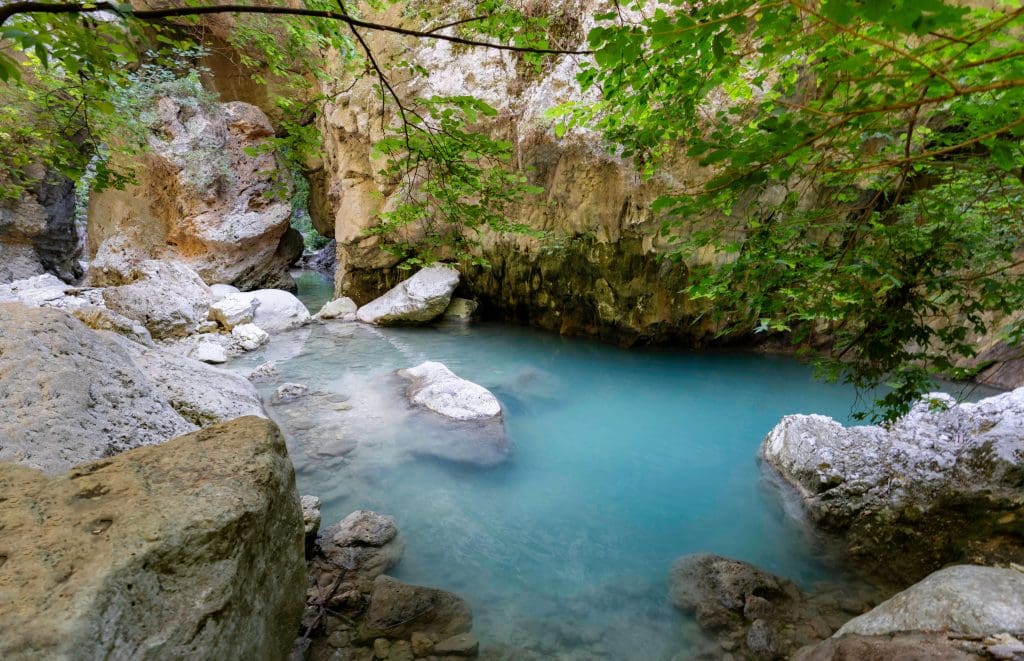 The peaceful bright blue waters of Nydri waterfalls in Lefkada are one of the best hidden gems of Greece.