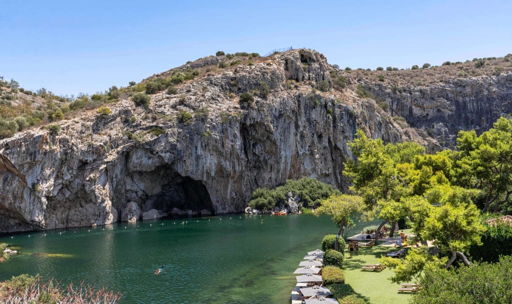 Emerald waters at the base of a cliff at Vouliagmeni Lake is one of the best things to do in Athens Greece.