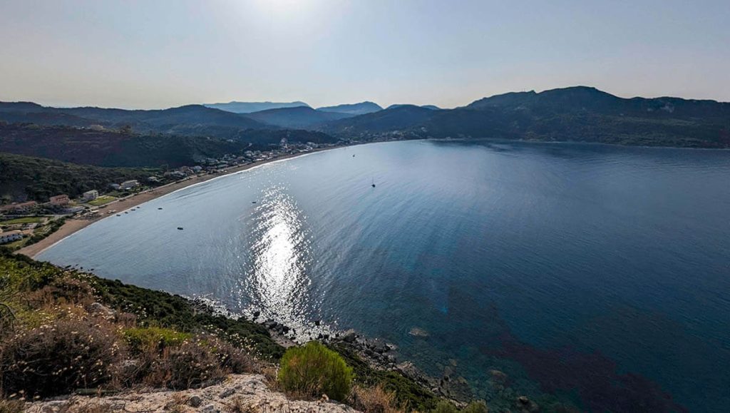 Looking down on the cove of Agios Goergios Beach full of fun water activities.