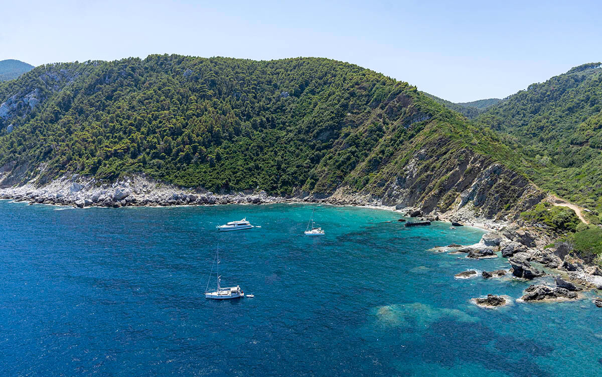 Looking down from the Mamma Mia church to see a couple boats sitting just off shore of Agios Ioannis, one of the best beaches in Greece.