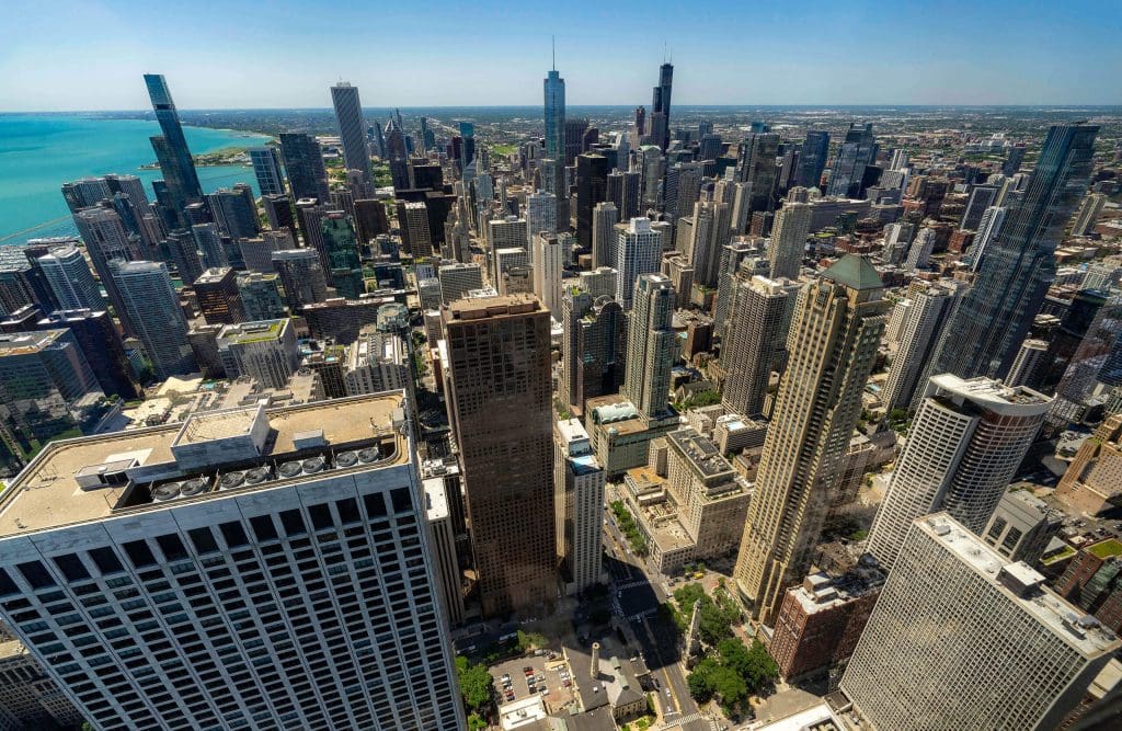 An aerial view over hundreds of Chicago buildings and streets from the 360 Chicago observation skydeck, one of the best photo spots in Chicago.