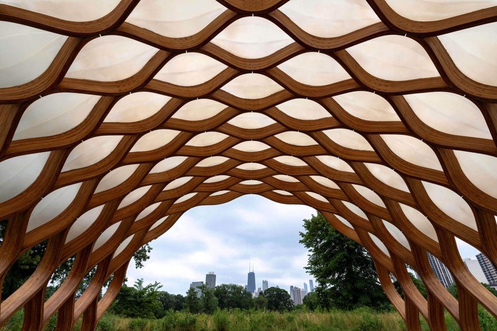 The People's Gas Pavilion, a honeycomb pattern of wood with Lincoln Park and the city skyline in the distance is a unique and one of the best photo spots in Chicago.