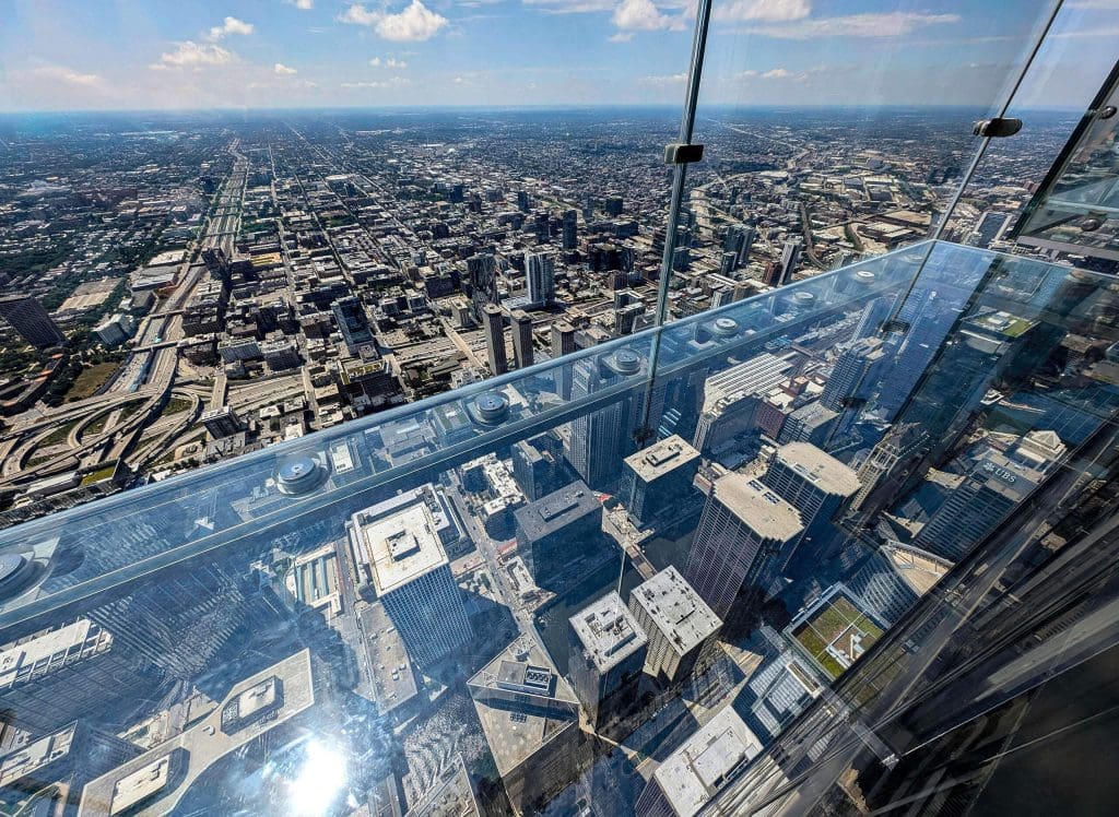 Looking out over the city through the glass walls and floor of the Willis Tower Skyview, one of the best photo spots in Chicago.