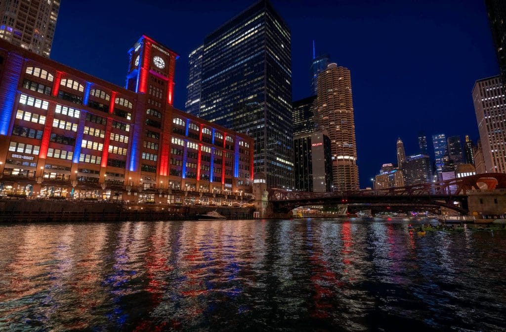 Lights of the Chicago skyline dazzle in the night sky while reflecting off the Chicago River, in one of the best spots in Chicago.