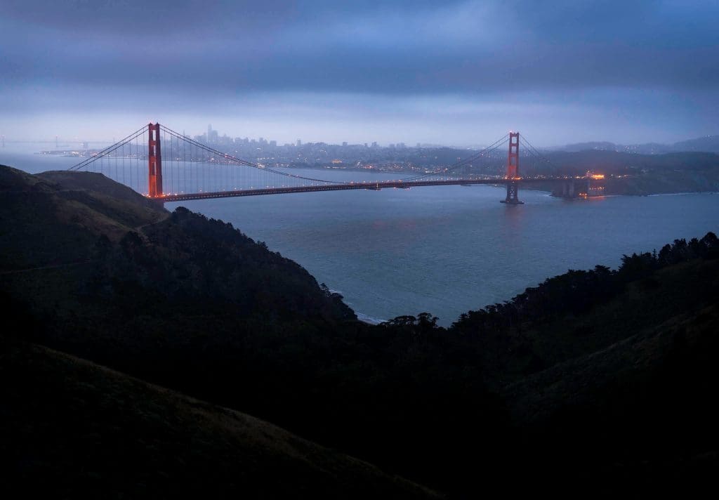 Looking on to the illuminated bridge and city from Conezelman Road one of the best Golden Gate Bridge viewpoints.