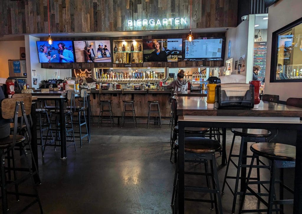 Open tables and chairs sitting in front of the full bar at the Dog Haus in downtown Phoenix.