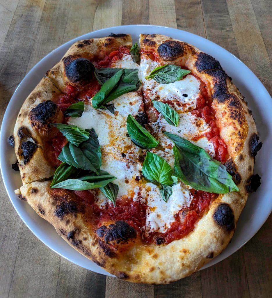 Melty cheese, sauce, and fresh basil make up the best pizza in Arizona at Pizzeria Bianco one of the best restaurants in Phoenix Arizona.