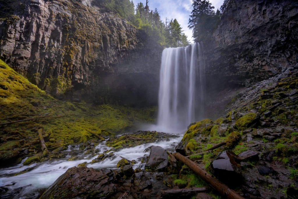 The dreamy scene of the Tamanawas Falls flowing down with mossy rocks around the bottom makes for one of the best hikes in Oregon.