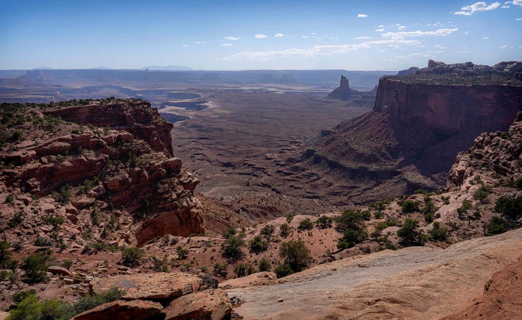 Overlooking the open and twisting canyons of the Canyonlands, an expansive Utah landscape.