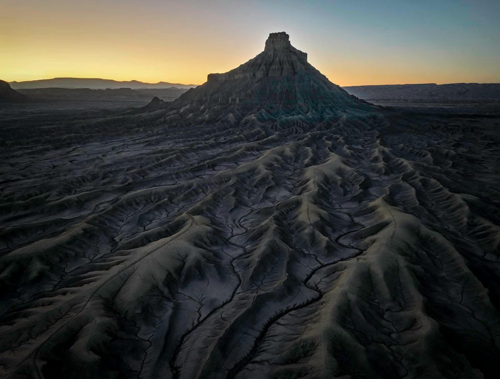 The waves and rigid lines leading up to the Factory Butte as the sun rises in the background makes for a one of a kind Utah landscape.