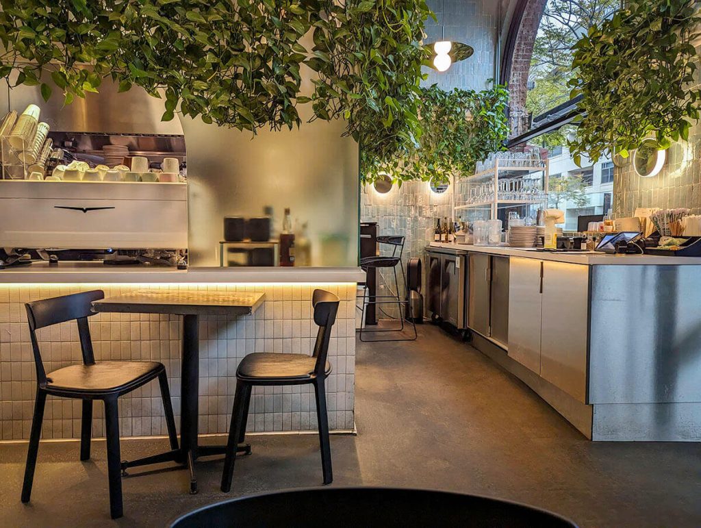 Long vines hang from tall shelves over tables at one of the most unique restaurants in Los Angeles, Interstellar.