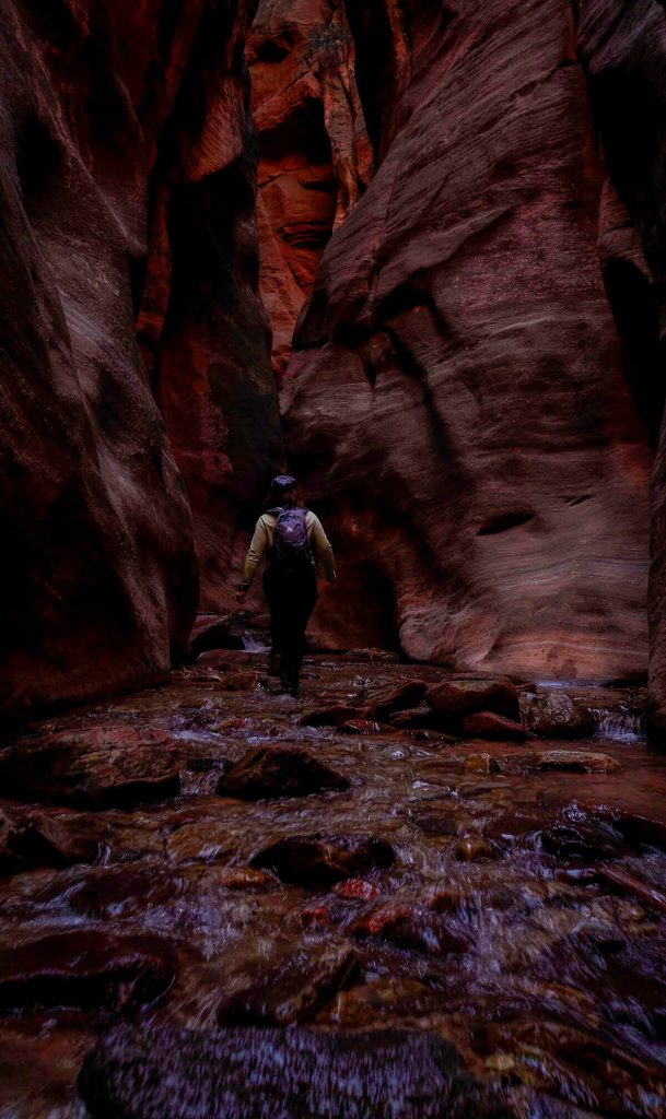 Splashing thtrough the flowing water as it moves down the canyon of Kanarra Falls, a top hiking trail in Utah.