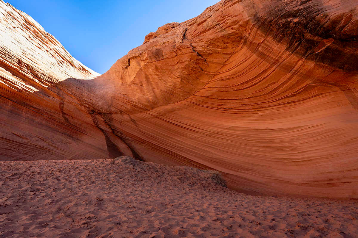 Waving lines flow through the overhang rock walls at the Page Shores Amphitheatre, a secluded spot for Arizona pictures.