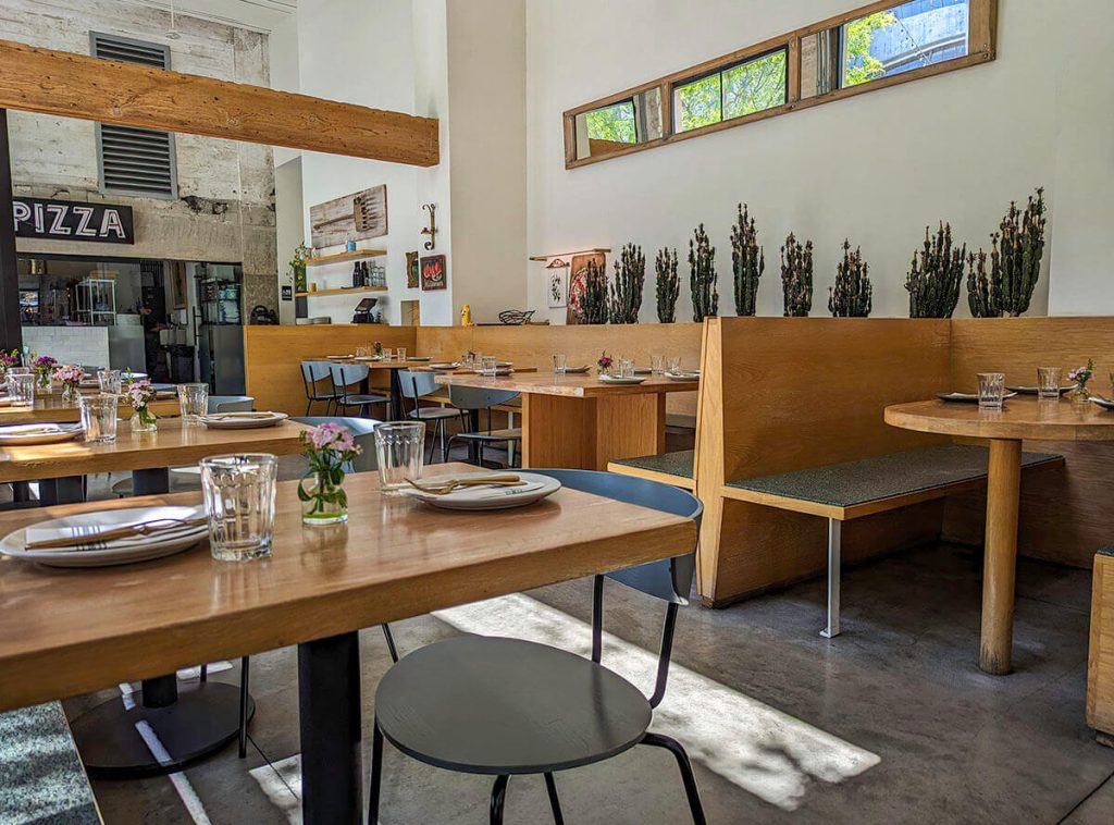 Open tables and chairs make up the sleek interior of Pizzeria Bianco Los Angeles.