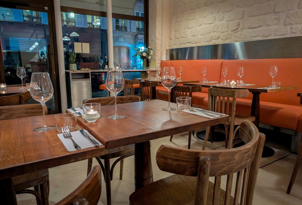 Open tables and chairs sit in the quaint Italian eatery of Adami in Paris.