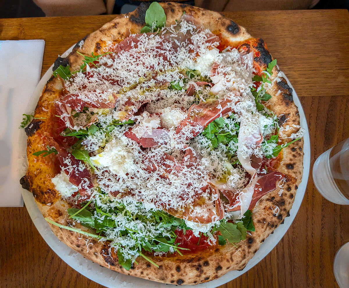 Looking down at a chaotic yet delicious pizza pie at Louie Louie in Paris.